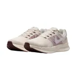 Championes de running Nike Run Swift 3, de color beige con detalles en lila y el swoosh en blanco.