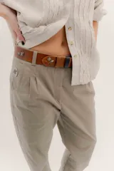 Cinturón de cuero marrón con hebilla negra y detalles metálicos en forma de rosas y rombos.