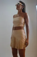 Short pollera color beige con flecos largos.