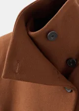 Abrigo largo de lana virgen en color marrón, con cuello solapa grande, cierre frontal y cinturón ajustable del mismo tejido. Presenta una silueta recta y bolsillos laterales.