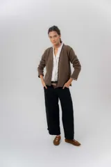 Pantalón de gabardina de algodón color negro, con calce barrel, cintura media baja, recortes de diseño y detalle de botones en el ruedo para ajustar el volumen.