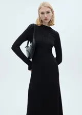 Vestido midi de punto acanalado en color negro, con cuello perkins y manga larga. Presenta un diseño evasé que se ajusta suavemente al cuerpo.