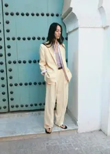 Blazer color beige confeccionado en mezcla de lino, viscosa y lyocell, de corte holgado con solapas de muesca, bolsillos con solapa en los laterales y cierre frontal de un botón.