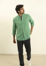 Camisa de manga larga confeccionada en una mezcla de algodón y lino, con cuello abotonado, bolsillo frontal en el pecho y cierre de botones.
