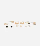 Kit de aros metálicos dorados con seis pares variados, que incluye aros argollas lisas, aros con textura de cadena, aros con dijes colgantes de corazón esmaltado en negro, y pequeños aros abridores con detalles de estrella y piedras de strass.