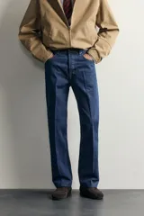 Jeans de denim azul oscuro sin lavados, corte recto con raya frontal planchada, tiro medio, cinco bolsillos y cierre frontal de botonadura. Colección especial Aaron Levine x Zara.