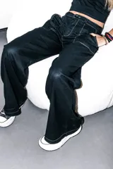Pantalón negro de lino con tiro medio, elástico en la cintura trasera, bolsillos delanteros carpinteros en contraste blanco y botón marmolado.