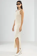 Vestido largo tejido color crema, con cuello halter y espalda baja.