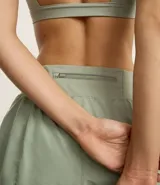 Bermuda deportiva tipo runner, color verde menta, confeccionada en microfibra con cintura elástica. Tiene un corte holgado y bajo redondeado.