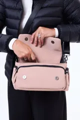 Bandolera de diseño funcional con cierre superior y tapa frontal. Cuenta con dos bolsillos laterales con cierre y un bolsillo frontal. Incluye una correa larga ajustable y desmontable.