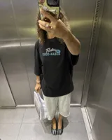 Remera oversize de color verde militar con efecto acid wash y diseño estampado en la espalda que incluye un camión de remolque y texto alusivo.