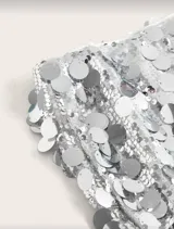 Minifalda de lentejuelas plateadas con diseño de tiro bajo y ajuste ceñido.