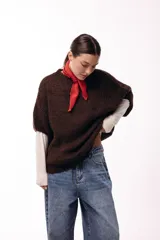 Sweater de tejido de punto grueso con silueta amplia y mangas 3/4. Presenta un diseño de calce relajado con cuello redondo y textura voluminosa.