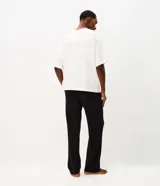 Pantalón de pijama masculino de corte recto, confeccionado en tejido de modal, poliéster y elastano. Presenta un diseño liso con cintura elástica y cordón ajustable para mayor comodidad.