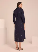 Vestido camisero midi color azul marino con estampado de lunares blancos, cuello camisero, mangas 3/4 y cinturón de lazo.