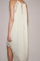 Vestido largo ZARA Woman Collection confeccionado en hilatura de viscosa de color crudo, con cuello halter, tirantes finos, detalles de encaje a tono y bajo asimétrico.