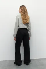 Pantalón de jean azul oscuro, de corte ancho, con cintura alta, pinzas delanteras y bolsillos laterales.