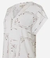 Pijama de dos piezas compuesto por una blusa de manga corta con escote en V decorado con encaje y un pantalón estilo capri con cintura elástica y terminaciones de encaje en el ruedo. Presenta un estampado floral delicado sobre fondo claro.