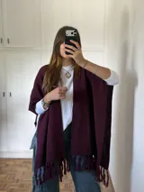 Ruana abierta de tejido de punto en color bordó, con diseño de textura sutil y terminación de flecos en el ruedo.