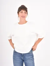 Remera negra de corte holgado, con cuello redondo y mangas cortas con dobladillo ancho.