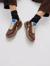 Sneaker Club 82 de cuero, color negro con detalles en beige y suela marrón. Cuenta con cordones off-white y una altura de suela de 3 cm.