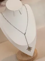 Collar de acero quirúrgico con cadena de eslabones alargados tipo papel y dije colgante en forma de flor abstracta.