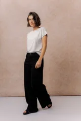 Pantalón de jean negro de corte wide leg, tiro alto y con costura vertical frontal.
