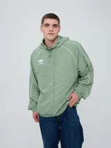 Campera rompevientos Umbro modelo Venti, de color negro con líneas blancas en las mangas y hombros, capucha con cordón de ajuste y cierre frontal completo. Cuenta con el logo de la marca bordado en el pecho.