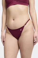 Bombacha tipo colaless color bordó, con cintura regulable mediante herrajes metálicos y detalle de logo bordado en el frente. Confeccionada en microfibra sin costuras.