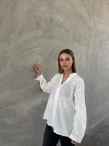 Camisa blanca de mangas largas con bordados florales.