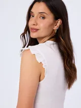 Remera blanca sin mangas con textura fruncida y volados sutiles en los hombros, cuello redondo y corte ajustado.