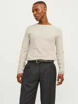 Sweater de manga larga con cuello redondo, confeccionado en tejido de punto con textura estructurada. Presenta un diseño minimalista con un pequeño parche de marca en el ruedo inferior.