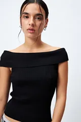 Top tejido de punto acanalado color blanco, con escote bardot que deja los hombros al descubierto.