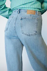 Jeans de tiro alto con corte wide leg y pernera ancha. Presenta bolsillos de plastrón en el delantero y cierre frontal con cremallera y botón.