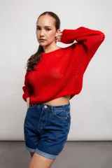 Buzo color crudo de tejido calado con transparencia, de corte holgado y mangas largas.