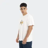 Remera de corte oversize color blanco, con cuello redondo y estampado gráfico central con el logo de la marca Reef en tonos amarillo y azul.