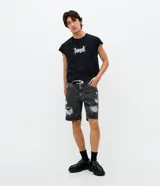 Bermuda de jean azul claro con diseño slim, presenta roturas y efecto desgastado (destroyed) en la parte frontal y terminaciones deshilachadas en el bajo. Cuenta con cierre tradicional de botón y cremallera, trabillas para cinturón y bolsillos laterales y traseros.