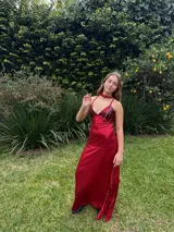 Vestido largo azul con escote en V y top de lentejuelas, tirantes finos cruzados en la espalda, recortes cut-out laterales en la cintura y falda larga con tajo y volados.