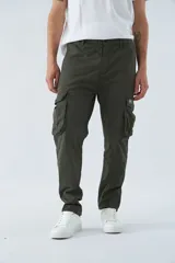 Pantalón cargo color beige, corte slim, con cierre y botón en la cintura, pasacintos, bolsillos cargo con botones y sin puños.