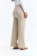 Pantalón de punto de tiro medio con corte recto y fit relajado. Presenta costuras verticales frontales que estilizan la silueta y bolsillos laterales.