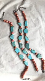Collar con cadena plateada, cuentas redondas color salmón y piedras irregulares de turquesa.