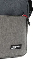 Morral de poliéster en dos tonos de gris, con dos bolsillos frontales y correa ajustable negra.