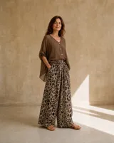 Pantalón wide leg de tiro alto con cintura elastizada y bolsillos laterales, confeccionado en tela ligera con estampado animal print tipo leopardo en tonos marrones y beige.