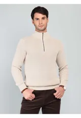 Sweater de punto en color beige, con cuello alto y cierre frontal parcial. Diseño de manga larga con puños y ruedo acanalados.