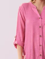 Blusa Ninety color beige con textura, cuello base con escote en V y abertura central con botones. Tiene un bolsillo en el pecho y mangas 3/4 regulables con presilla y botón.