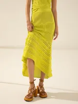 Pollera larga color amarillo, de tejido calado con diseño floral y terminación irregular con flecos.