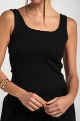 Top musculosa de punto acanalado en color negro, con escote redondo amplio y corte ajustado al cuerpo.