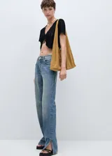 Pantalón de jean de tiro medio con diseño recto y cinco bolsillos. Presenta aberturas laterales en el bajo y cierre frontal con cremallera y botón.