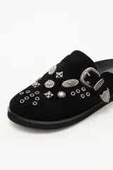 Zueco de cuero descarne negro con diseño de estilo western, decorado con tachas metálicas plateadas y una hebilla lateral ajustable.