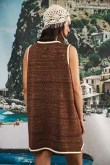 Vestido corto sin mangas, de tejido de punto en color azul marino con efecto jaspeado o tweed en tonos claros. Presenta un corte amplio y relajado, con cuello redondo y bordes en contraste.